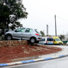 El coche suspendido sobre el margen de piedra de la rotonda después de impactar contra un pino.