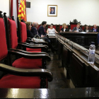 Primer plano de las sillas vacías de los concejales del PSC en el pleno de Tortosa y al fondo la pared donde ha desaparecido la foto del rey Felipe VI.