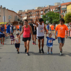 La pequeña Txell García, con camiseta azul, corriendo con su padre y su primo.