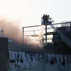 Un equip de bombers ataca les flames d'una nau del grup Balfegó incendiada el 22 de juny.