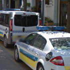 Tres vehículos de la Policía Municipal de Girona aparcados delante de la comisaría.