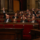Imagen de Eduard Pujol, de JxCat, y Sergi Sabrià, de ERC, votando la propuesta de resolución que legitima Puigdemont, el 1 de marzo de 2018.