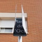 Imatge de la placa de la plaça 1 d'Octubre completament doblegada.