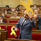 El diputat de Cs, Carlos Carrizosa, retirant un llaç del banc dels consellers al Parlament.
