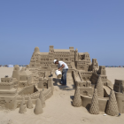 Imagen de archivo de un hombre construyendo un castillo de arena.