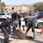 Policías abriendo la tapa de una alcantarilla cerca del Parlament de Catalunya