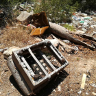 Restos de lo que queda de una butaca, a pocos metros de material de todo tipo abandonado a tierra.