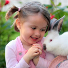 Nena amb un conill com a animal de companyia.