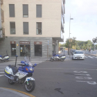 Una moto de la Guardia Urbana, aparcada en un lugar prohibido delante de una cafetería.