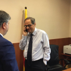 Imatge general del candidat a la investidura, Quim Torra, parlant per telèfon amb Carles Puigdemont, sota la mirada d'Albert Batet d'esquenes.