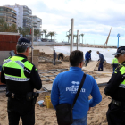 Agentes de la Guardia Urbana de Salou, hablando con el propietario de un chiringuito de los daños que ha sufrido la terraza a causa del temporal, en un extremo de la playa de Levante.