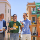 Josep Bertran, Enric Garriga i el dissenyador Edu Polo al Pla de la Seu, amb la lona commemorativa penjada al darrera.