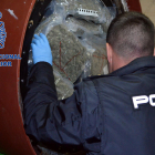 Un agente de la policía española inspeccionando el cilindro pintando de la furgoneta interceptada.