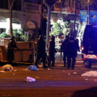 Pla general d'agents antidisturbis dels Mossos d'Esquadra retirant contenidors tombats al mig del carrer a Barcelona durant els aldarulls posteriors a la manifestació del 25 de març