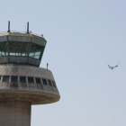 Un avió enlairant-se amb l'antiga torre de control al costat.