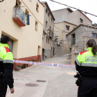 Dos agentes de los Mossos D'Esquadra delante del precinto que da acceso a la calle donde vivían los vecinos que se han peleado en Arbolí.