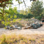 En primer terme, restes recollides la setmana passada i, al fons, un dels joves participants.