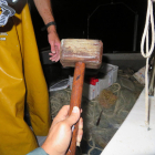 Amb una maça de fusta es colpeja l'embarcació tot fent sorolls perquè els peixos marxin cap a la xarxa. .
