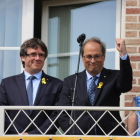 El president Quim Torra aixeca un puny al costat de Puigdemont, en un acte a Waterloo.