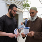 El portavoz de la mezquita, a la izquierda, muestra la información de los folletones que repartirá el centro.