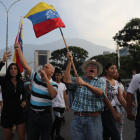 Simpatitzants del president interí Juan Guaidó fan onejar banderes aquest dimarts en la base militar La Carlota.