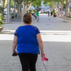 Una dona passejant un gos. Imatge d'arxiu.