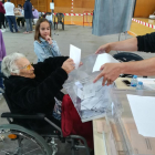 Amèlia Guardià de l'Arboç a sus 107 años ejerciendo su derecho al voto, acompañada de la bisnieta, que coge la silla y su bisnieto.