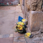 Una bossa de brossa deixada al terra pintada de groc.