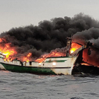 Pla detall de l'embarcació cremant al mar al Port de la Selva.