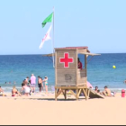 Una bandera verda onejant a una platja.