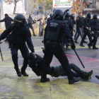 Dos agentes de los Mossos, arrastrando a un manifestante antifascista a la plaza U de Octubre de Gerona.