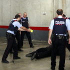Mossos d'esquadra fan pràctiques amb la pistola elèctrica, coneguda com a Taser; al terra, un agent, vestit amb proteccions, després que li hagin disparat en la recreació d'una situació.