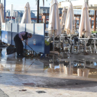 Un treballador d'un restaurant del Carrer Trafalgar netejant la terrassa.