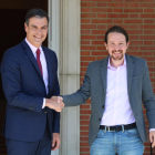 El presidente del gobierno electo, Pedro Sánchez, y el líder de Podemos, Pablo Iglesias, encajando manos en La Moncloa.