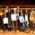 Foto de grup dels integrants de la iniciativa ciutadana de la Riuada Solidària de l'Espluga de Francolí, amb els cartells promocionals del programa d'actes solidaris 'Riumuntada', al teatre del Casal. Imatge del 14 de novembre del 2019