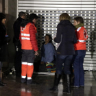 Pla obert de voluntaris de la Creu Roja i de membres de Serveis Socials atenent un sensesostre que dorm a l'entrada d'una botiga del carrer Unió de Tarragona. Imatge de l'11 de gener del 2018