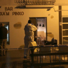 Un agente de la policía científica de los Mossos haciendo fotos de la fachada del bar Punxa'm Pinxo de Sant Carles de la Ràpita el 13 de diciembre de 2017.