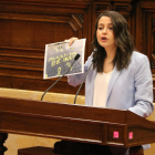La líder de Cs, Inés Arrimadas, enseña un cartel desde el atril del Parlamento, durante su última intervención al pleno de la cámara.