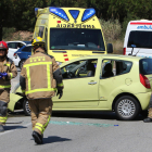 Imatge dels Bombers treballant en l'accident junt al cotxe que ha patit la col·lisió.