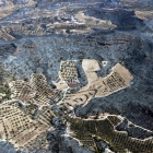 Vista aèria d'una zona agrícola i d'una construcció envoltades de zones cremades a l'incendi de la Ribera d'Ebre.