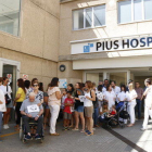 Plano general de una cincuentena de trabajadores de Pius Hospital de Valls concentrados delante de las puertas del centro hospitalario.