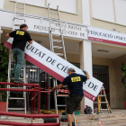 Dos operarios instalando el nuevo letrero de la Facultad de Ciencias de la Educación y Psicología de la URV.