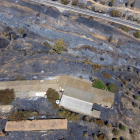 Imatge aèria captada amb dron de l'incendi de la Ribera d'Ebre on es pot veure una granja de bestiar afectada pel foc