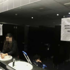 En primer terme, cartell informatiu en el mirall dels lavabos públics de dones del Mercat Central.
