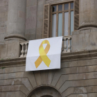 Plano medio de la pancarta con el lazo amarillo que hay en la fachada del Ayuntamiento de Barcelona.