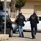 Dos agentes de los Mossos D'Esquadra llevando cajas de documentación que han requisado al Ayuntamiento de Deltebre a un vehículo policial.