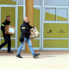 Dos agentes de los Mossos d'Esquadra con cajas saliendo del Ayuntamiento de Deltebre.