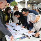 Fernández, tercera per l'esquerra, i tres persones en el moment de signar el document.