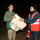 Un voluntari de Creu Roja entrega una manta a la Catarina, que dorm sota el riu Francolí amb la seva parella i una amiga.