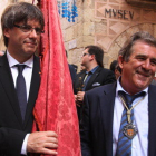 El president de la Generalitat, Carles Puigdemont, porta la bandera de la Vila Ducal al costat de l'alcalde de Montblanc, Josep Andreu, en una imatge d'arxiu.
